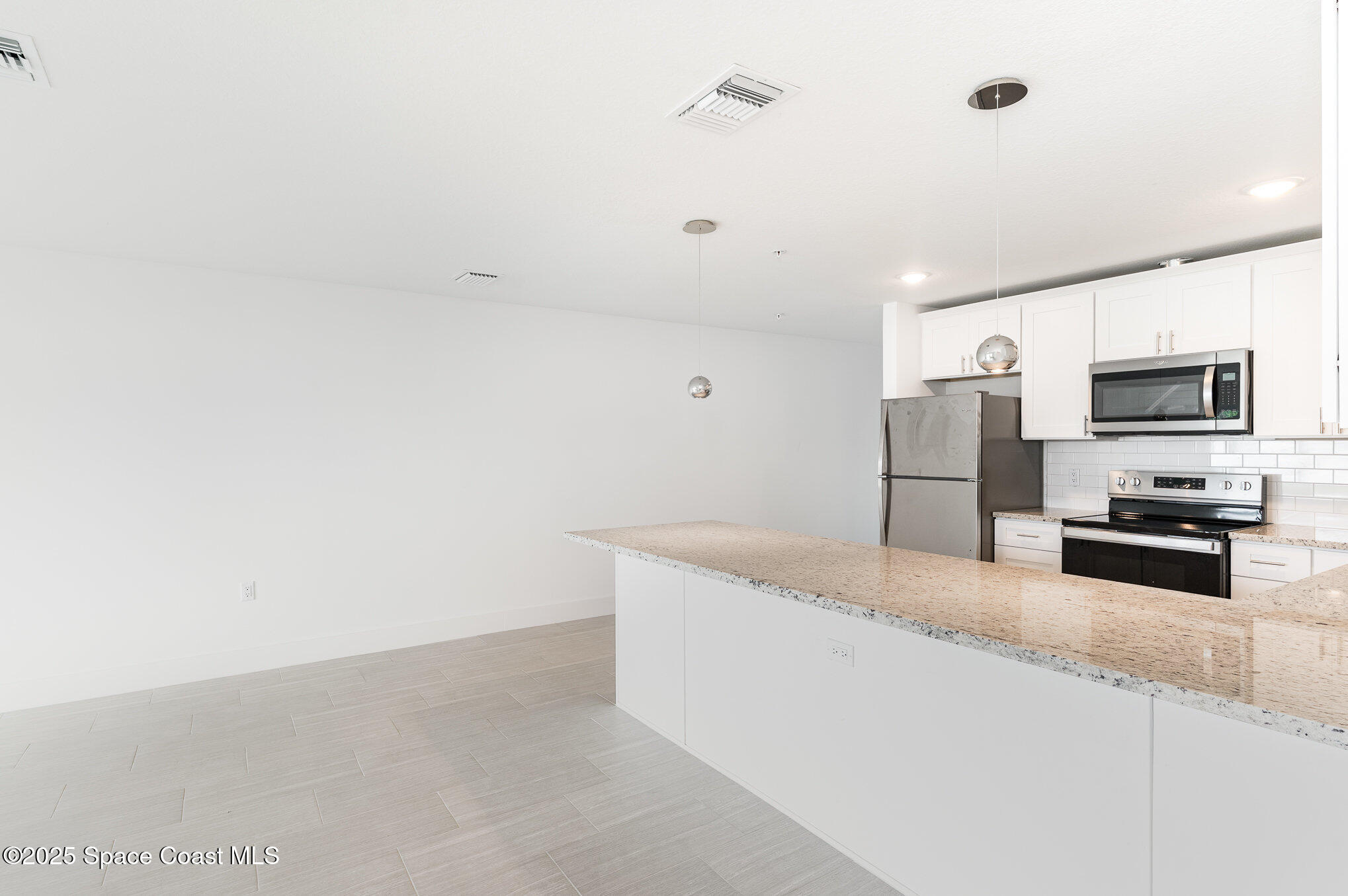 1635 Par Street Northeast, Unit 2103 Palm Bay, FL 32905 - Photo 7 of 36 a kitchen with granite countertop a refrigerator and a sink