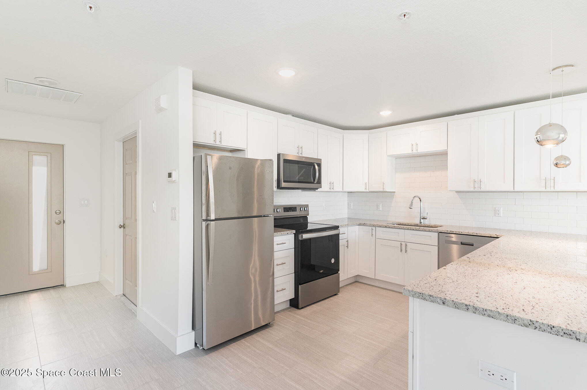 1635 Par Street Northeast, Unit 2103 Palm Bay, FL 32905 - Photo 8 of 36 a kitchen with granite countertop stainless steel appliances a refrigerator a stove top oven and sink