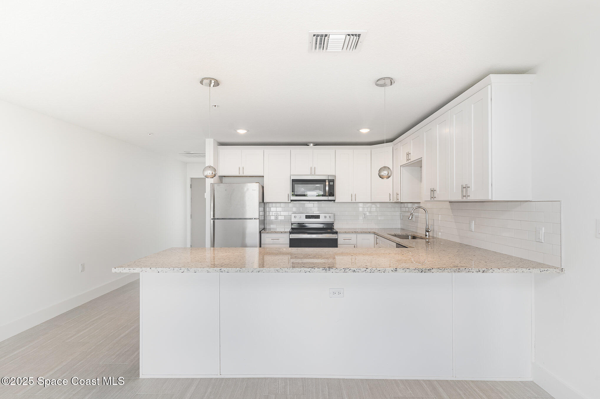1635 Par Street Northeast, Unit 2103 Palm Bay, FL 32905 - Photo 9 of 36 a kitchen with stainless steel appliances granite countertop a sink refrigerator and cabinets