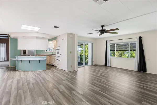 a view of kitchen with wooden floor and electronic appliances
