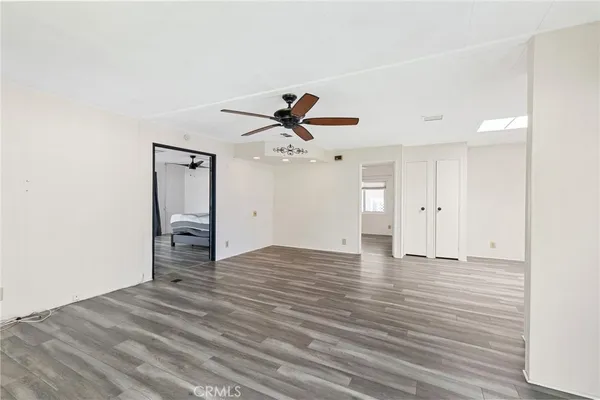 a view of empty room with wooden floor and ceiling fan