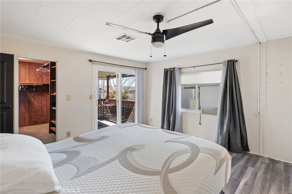 27701 Murrieta Road, Unit 227 Menifee, CA 92586 - Photo 18 of 36 a bedroom with a bed and a large mirror with a flat tv screen