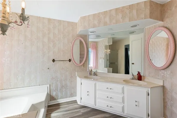 a spacious bathroom with a double vanity sink a mirror and a bathtub