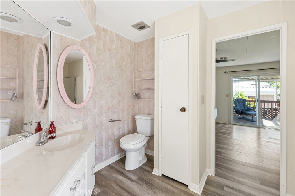 27701 Murrieta Road, Unit 227 Menifee, CA 92586 - Photo 25 of 36 a bathroom with a sink toilet a mirror and vanity
