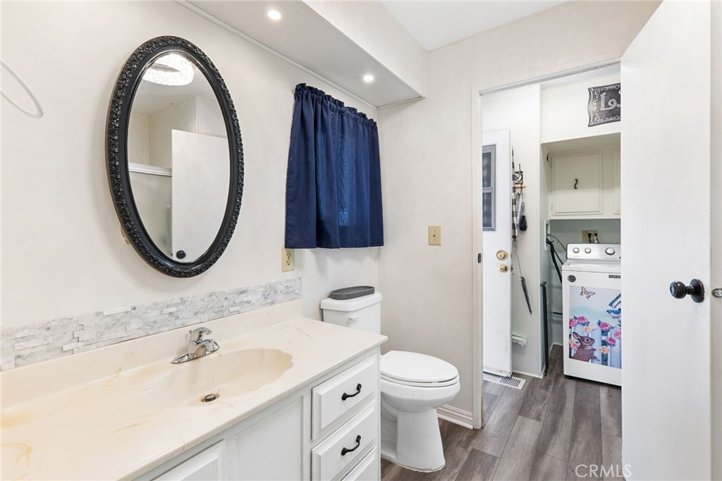 27701 Murrieta Road, Unit 227 Menifee, CA 92586 - Photo 28 of 36 a bathroom with a toilet sink and mirror