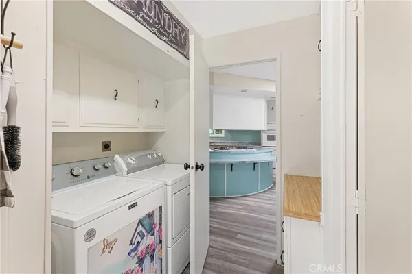 a utility room with cabinets washer and dryer