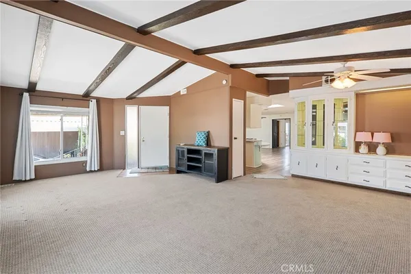 a view of an empty room with a fireplace and a window