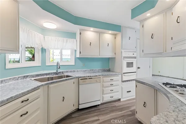 a kitchen with granite countertop a sink stove and cabinets