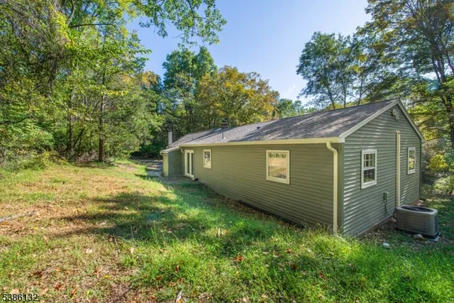 a view of a house with backyard and trees