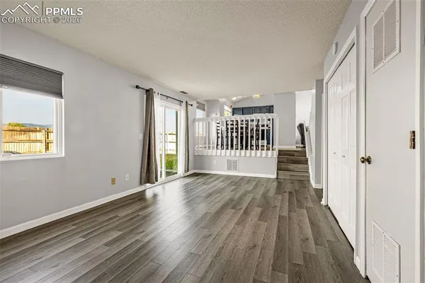 a view of a room with wooden floor and window