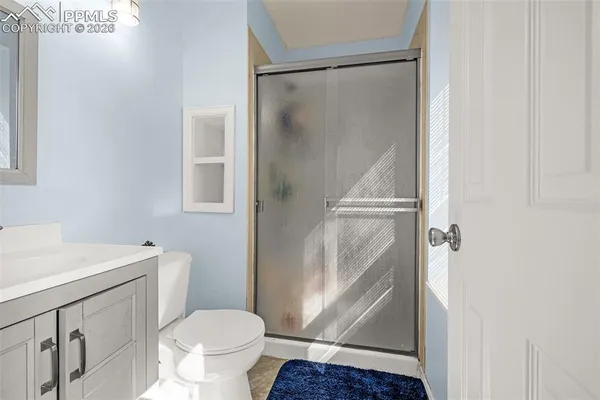 a bathroom with a granite countertop toilet and a sink