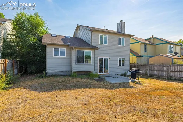 a view of a house with backyard and sitting area