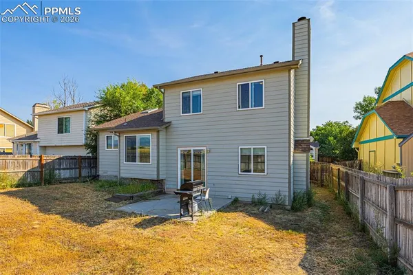 a view of a house with backyard and sitting area