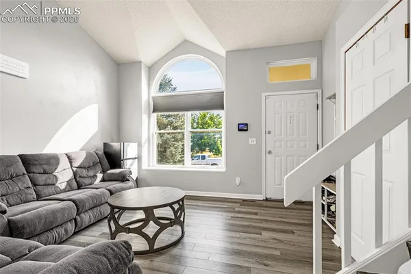 a living room with furniture and a wooden floor