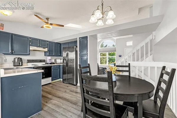 a kitchen with granite countertop a table chairs stove and refrigerator
