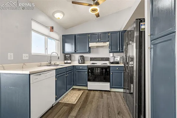 a kitchen with a sink cabinets stainless steel appliances and a window