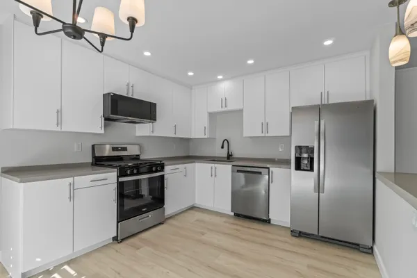 a kitchen with a stove top oven a refrigerator and cabinets