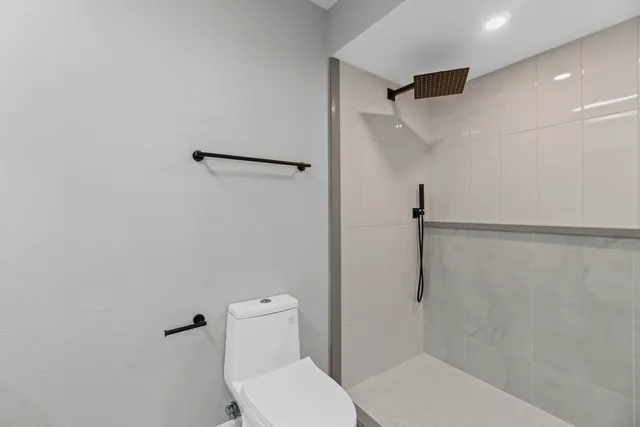 a bathroom with a granite countertop sink a toilet and a mirror