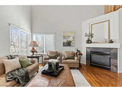 a living room with furniture a fireplace and a large window
