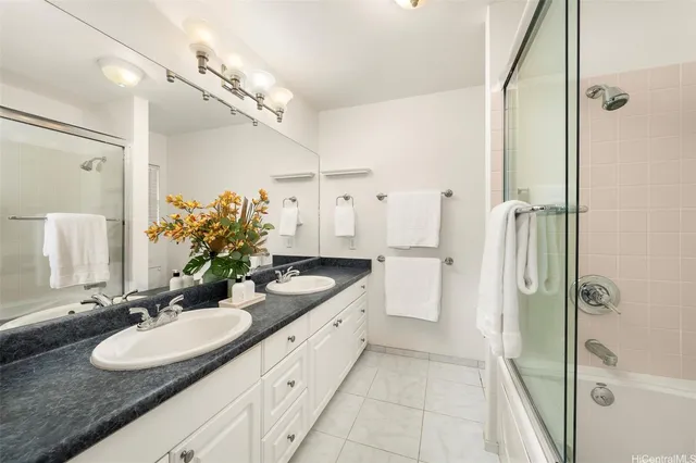a bathroom with a double vanity sink mirror and shower