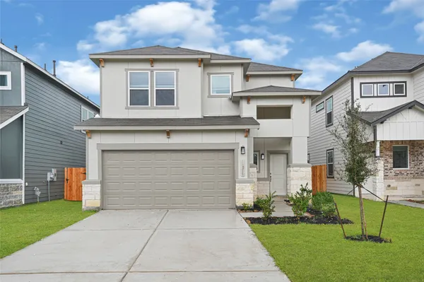 a front view of a house with a yard and garage