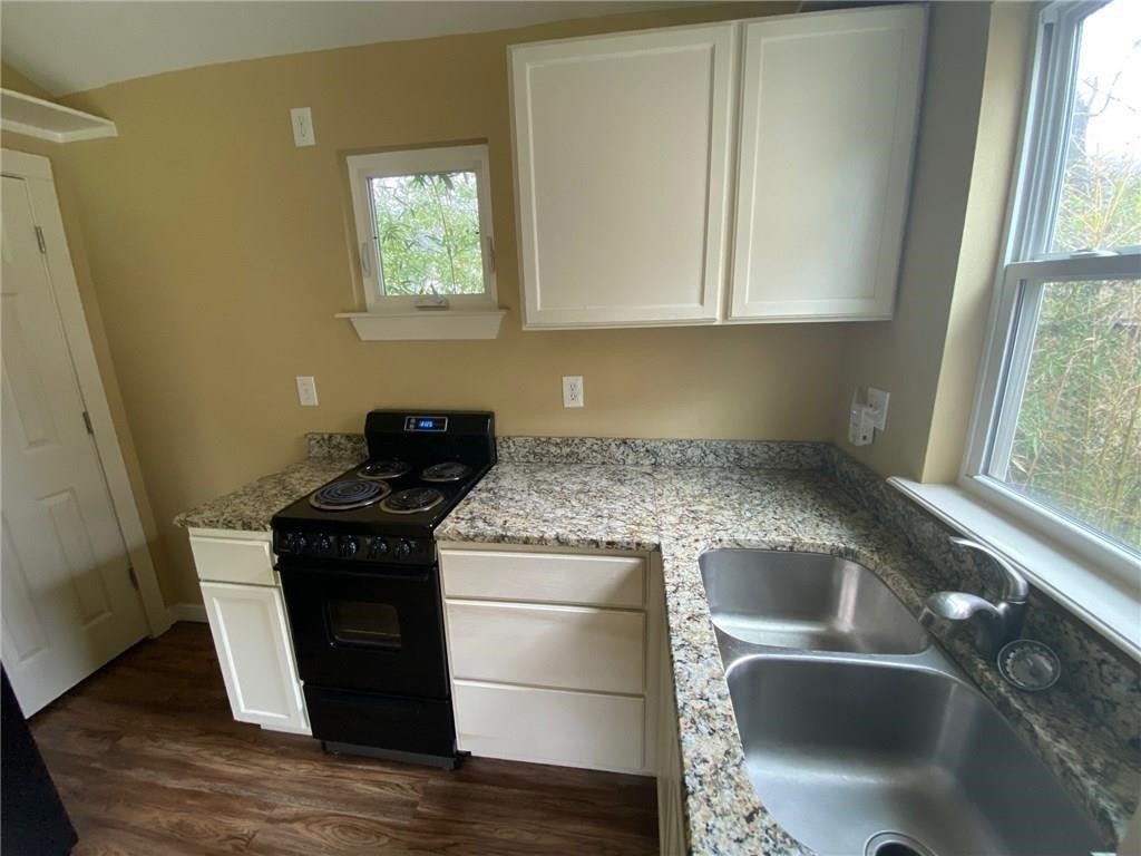 3308 Randolph Road, Unit B Austin, TX 78722 - Photo 5 of 16 a kitchen with granite countertop a sink and a stove top oven