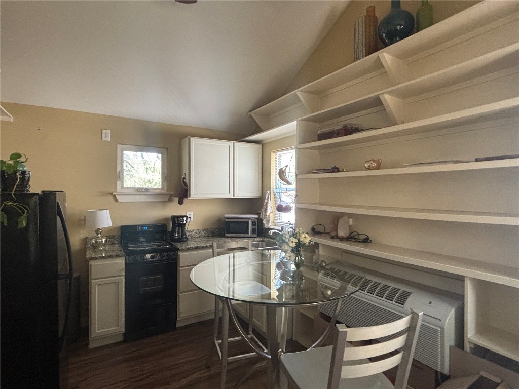 3308 Randolph Road, Unit B Austin, TX 78722 - Photo 6 of 16 a kitchen with a table chairs refrigerator and cabinets