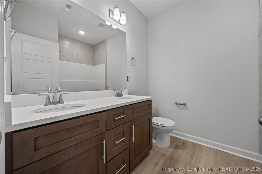 3180 Cameron Hill Road Cameron, NC 28326 - Photo 30 of 46 a bathroom with a granite countertop sink a toilet and a mirror