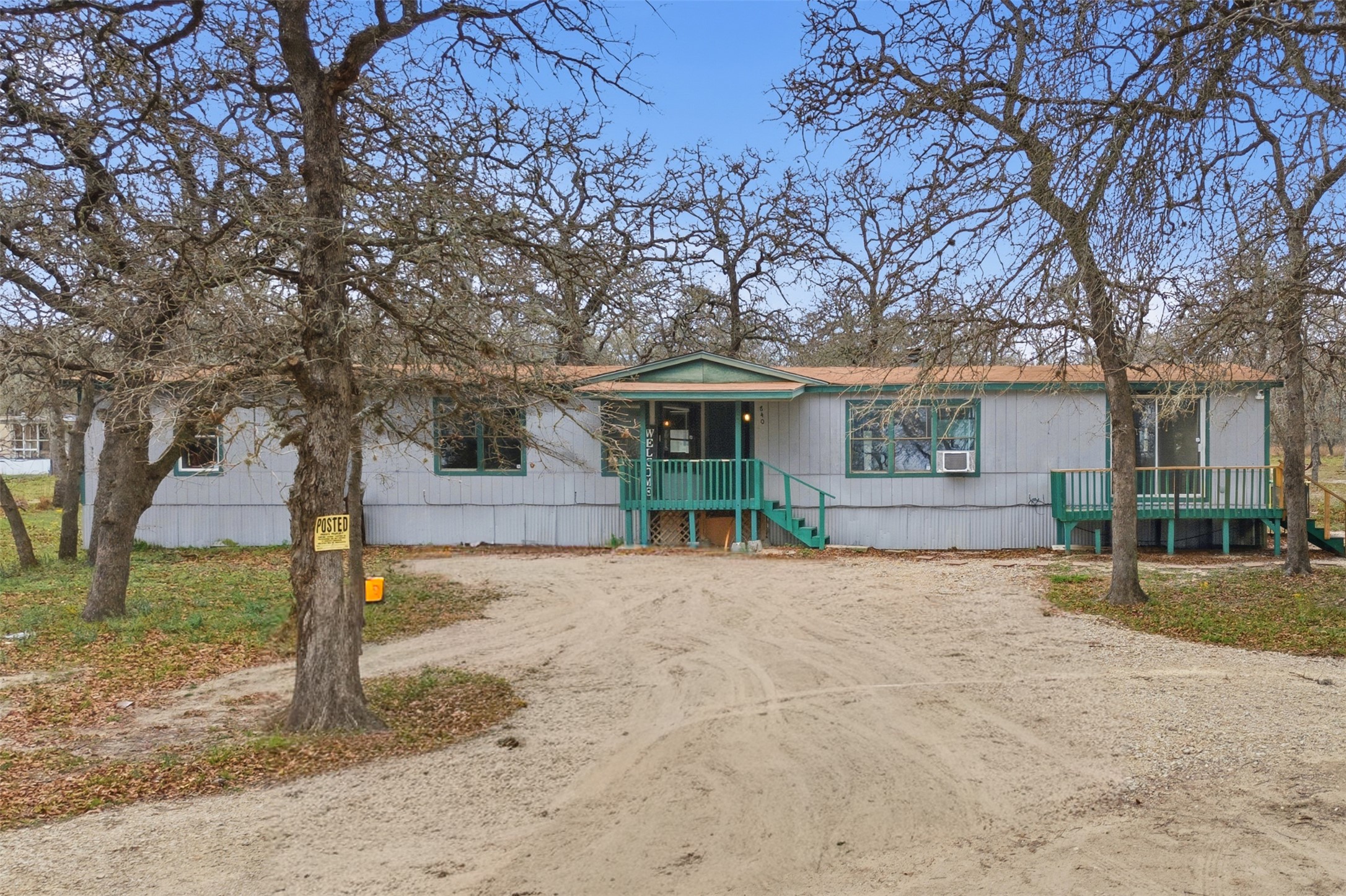 a front view of a house with a tree in center