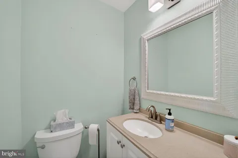 a bathroom with a granite countertop sink toilet and mirror