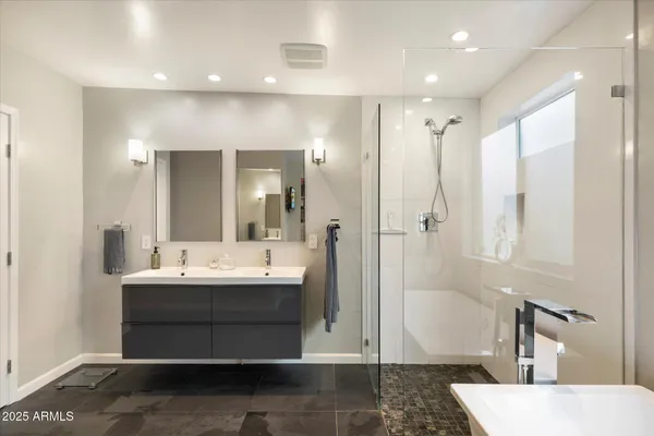 a bathroom with a tub a sink and a mirror