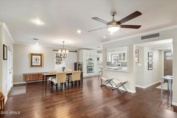 a living room with furniture kitchen view and a chandelier