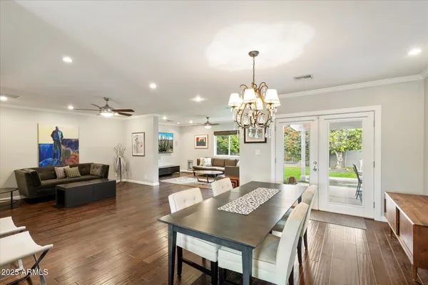 a view of a dining room and livingroom with furniture wooden floor a ceiling fan and a rug