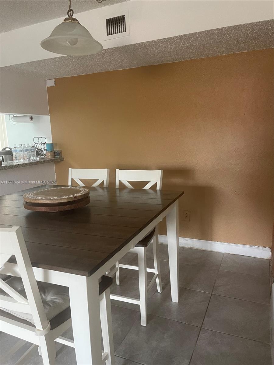 18230 Mediterranean Boulevard, Unit 1302 Hialeah, FL 33015 - Photo 15 of 42 a kitchen with a table and chairs in it