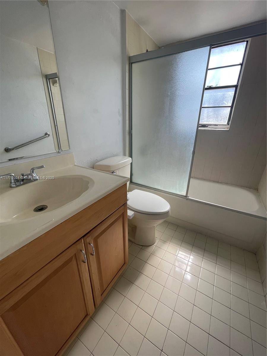 18230 Mediterranean Boulevard, Unit 1302 Hialeah, FL 33015 - Photo 23 of 42 a bathroom with a sink a toilet and mirror