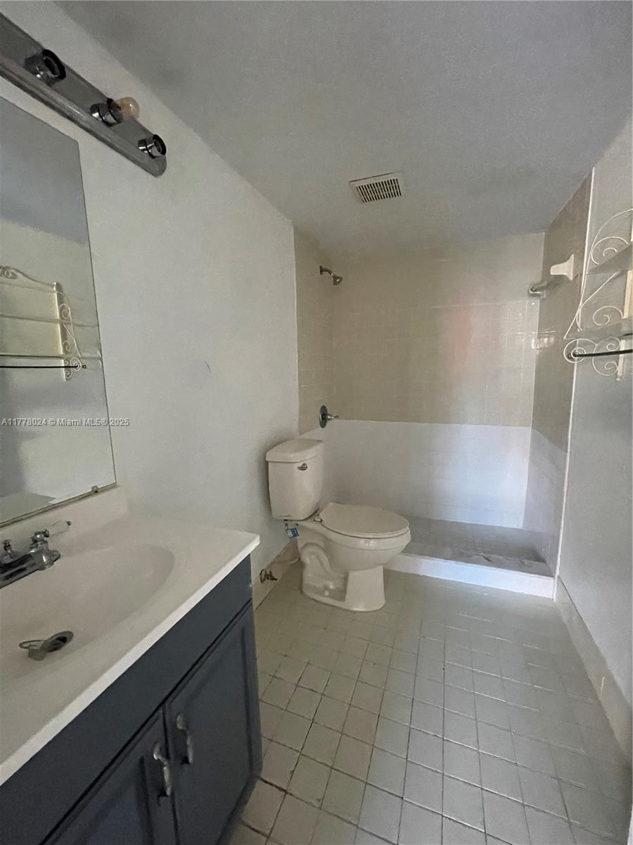 18230 Mediterranean Boulevard, Unit 1302 Hialeah, FL 33015 - Photo 29 of 42 a bathroom with a sink a toilet and shower
