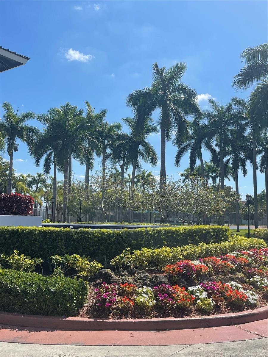 18230 Mediterranean Boulevard, Unit 1302 Hialeah, FL 33015 - Photo 30 of 42 a front view of a house with a yard and potted plants