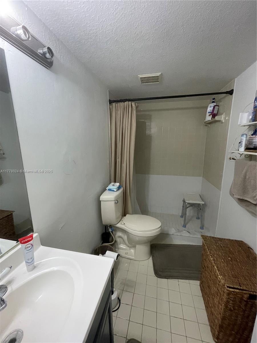 18230 Mediterranean Boulevard, Unit 1302 Hialeah, FL 33015 - Photo 5 of 42 a bathroom with a sink toilet and shower