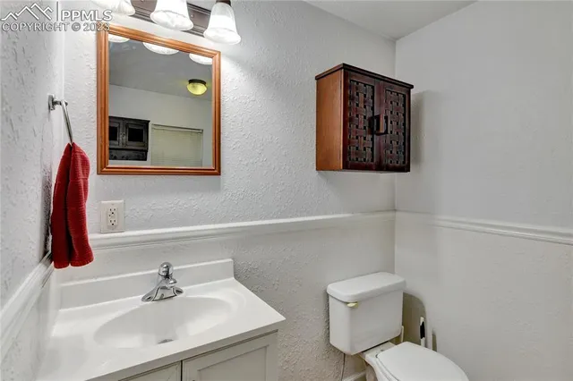 a bathroom with a toilet a sink and mirror