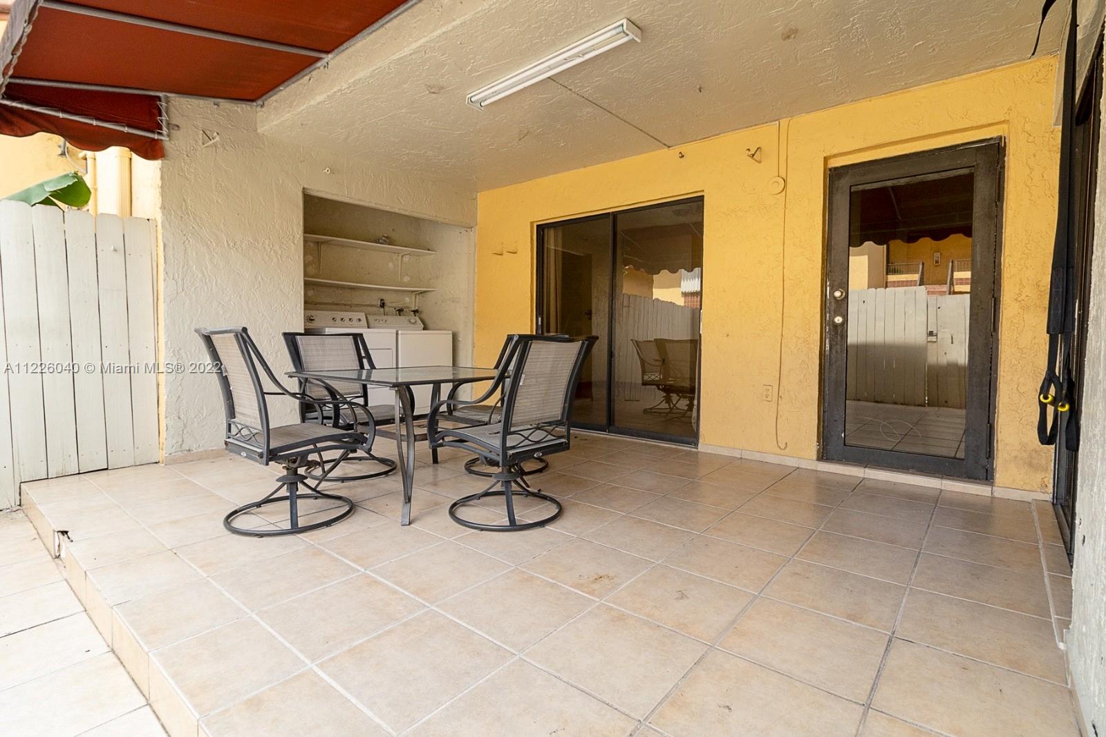 10897 Northwest 7th Street, Unit 1429 Miami, FL 33172 - Photo 16 of 17 a view of a patio with table and chairs