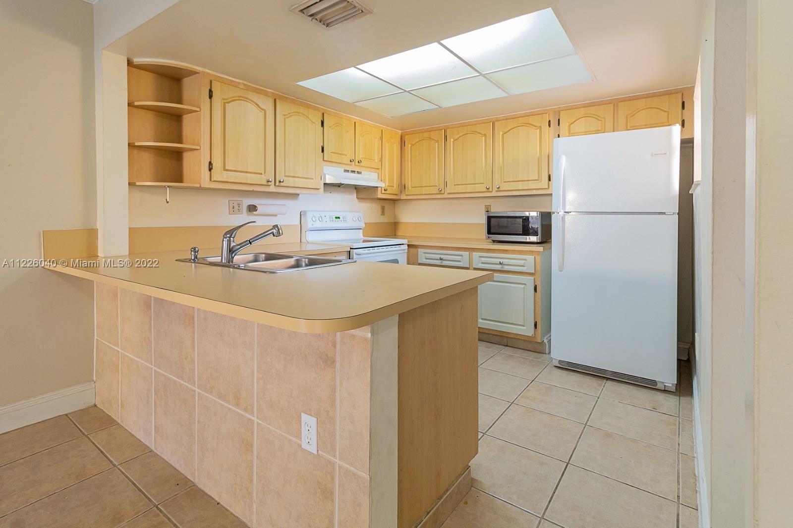 10897 Northwest 7th Street, Unit 1429 Miami, FL 33172 - Photo 2 of 17 a kitchen with stainless steel appliances a refrigerator sink and cabinets