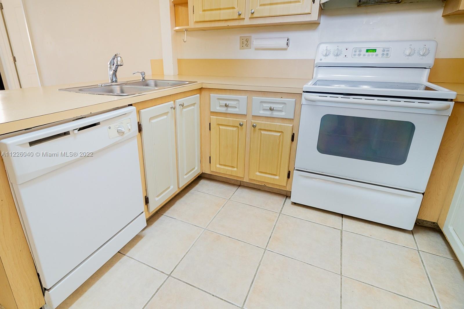 10897 Northwest 7th Street, Unit 1429 Miami, FL 33172 - Photo 3 of 17 a kitchen with granite countertop white cabinets and white appliances