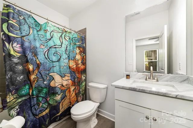 a bathroom with a granite countertop toilet sink and mirror