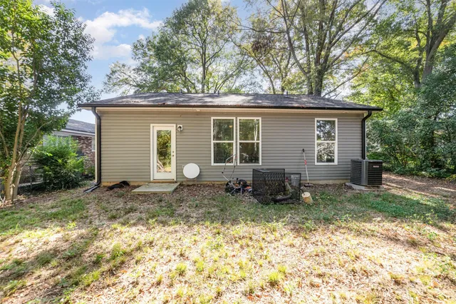 a view of a house with a yard and large tree