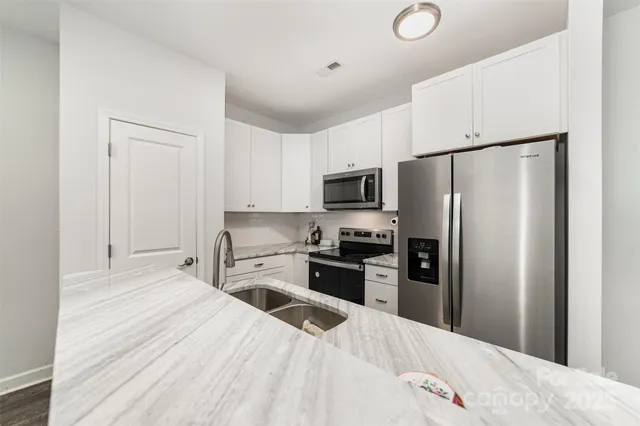 a kitchen with stainless steel appliances a refrigerator stove microwave and sink