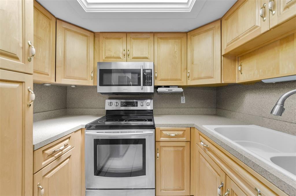 2836 Highlands Boulevard, Unit A Palm Harbor, FL 34684 - Photo 14 of 95 a kitchen with granite countertop a sink a stove and cabinets