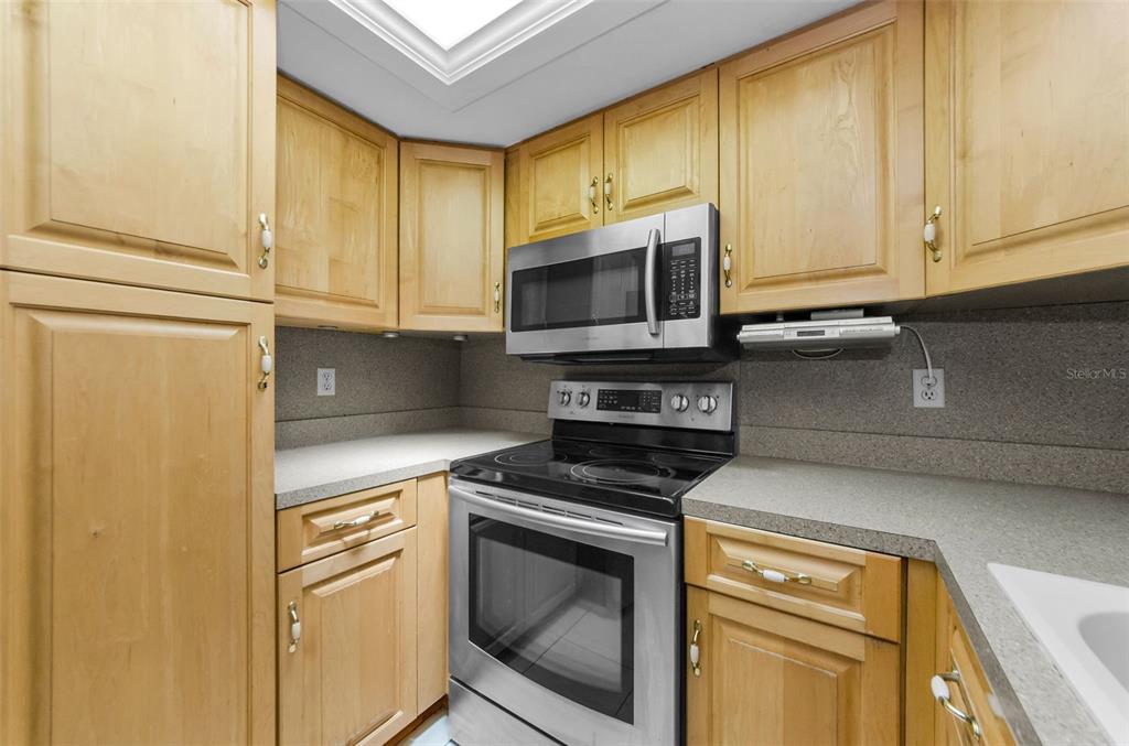 2836 Highlands Boulevard, Unit A Palm Harbor, FL 34684 - Photo 15 of 95 a kitchen with stainless steel appliances white cabinets and a stove top oven