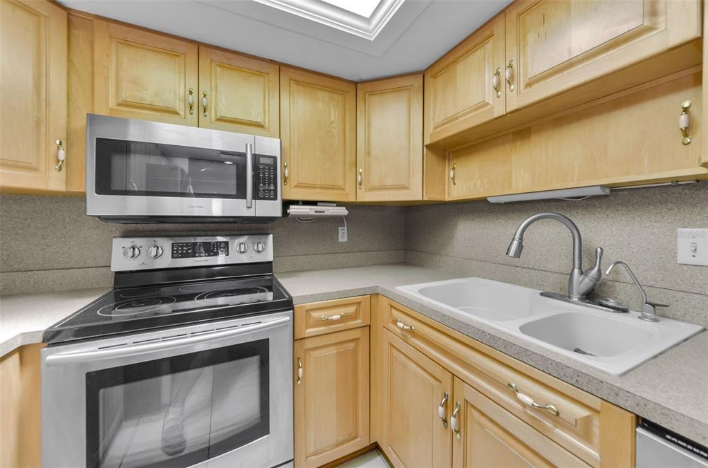 2836 Highlands Boulevard, Unit A Palm Harbor, FL 34684 - Photo 16 of 95 a kitchen with granite countertop a sink stainless steel appliances and cabinets
