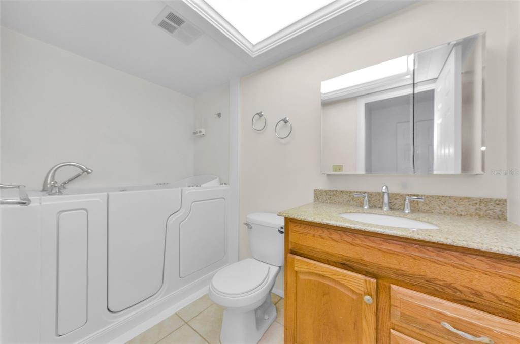 2836 Highlands Boulevard, Unit A Palm Harbor, FL 34684 - Photo 22 of 95 a bathroom with a granite countertop sink mirror vanity and toilet