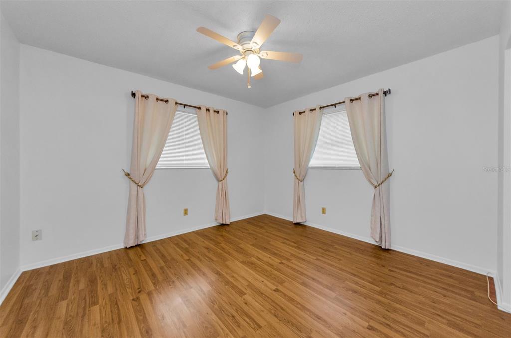 2836 Highlands Boulevard, Unit A Palm Harbor, FL 34684 - Photo 25 of 95 a view of empty room with wooden floor and fan